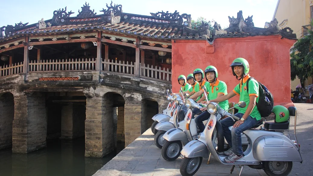 Vespa group at the Japanese Covered Bridge on a short Hoi An tour