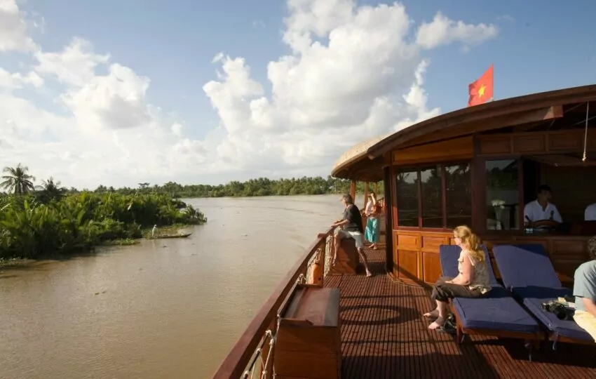 Guests relaxing on the upper deck as the Bassac cruises the Mang Thit river