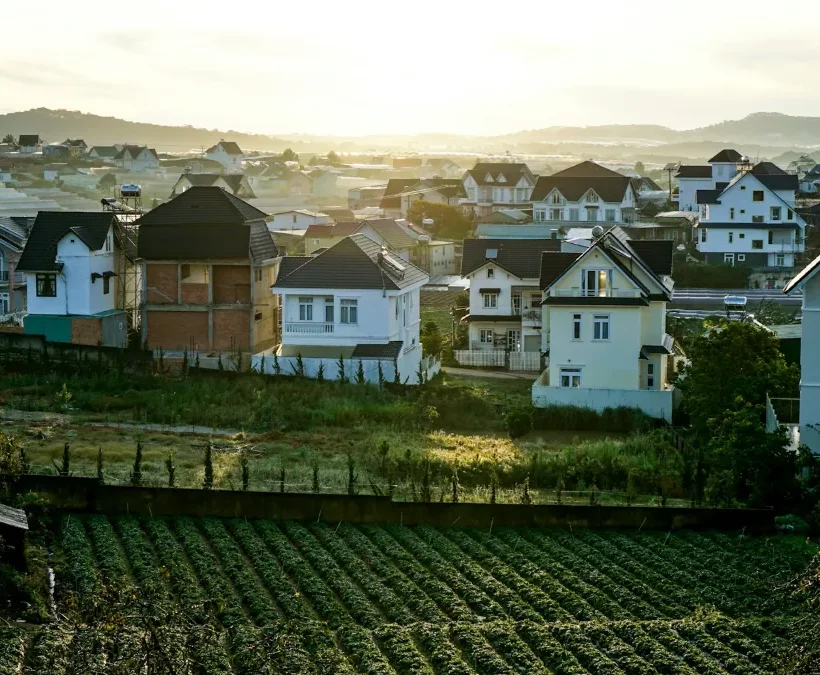 Colourful hillside villas and guesthouses above vegetable gardens in Dalat glowing in late-afternoon sun