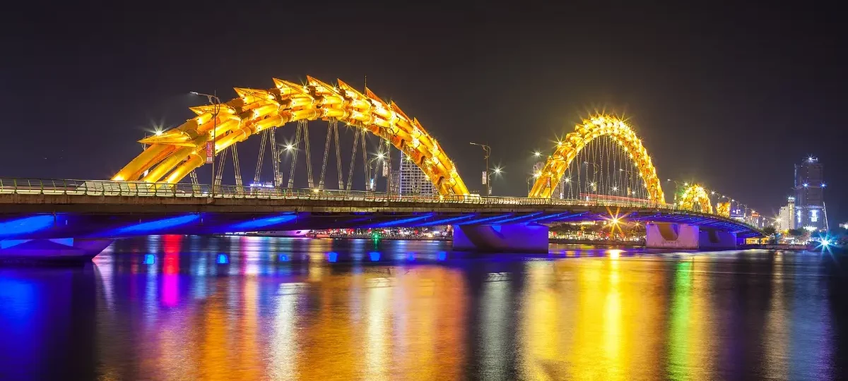 Dragon Bridge illuminated in colourful lights over the Han River at night, Da Nang