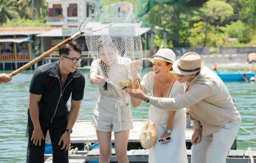 Guests looking at the catch at a floating fish farm on the Emperor Cruises Legend day cruise