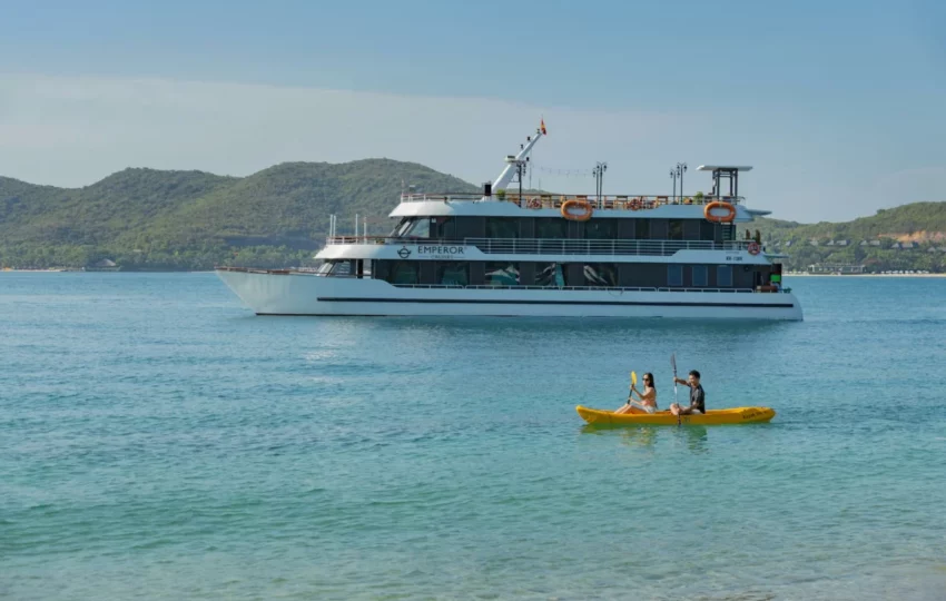 Couple kayaking beside Emperor Cruises Legend in Nha Trang Bay