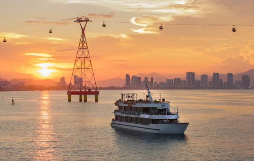 Emperor Cruises Legend cruising at sunset with the Nha Trang skyline and cable-car tower behind