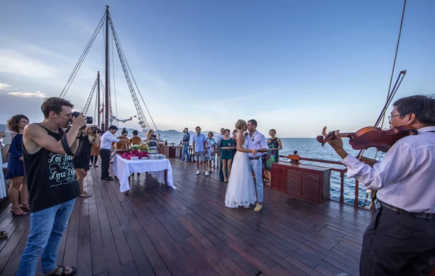 Violinist playing for guests on deck during the Emperor Cruises sunset cruise in Nha Trang