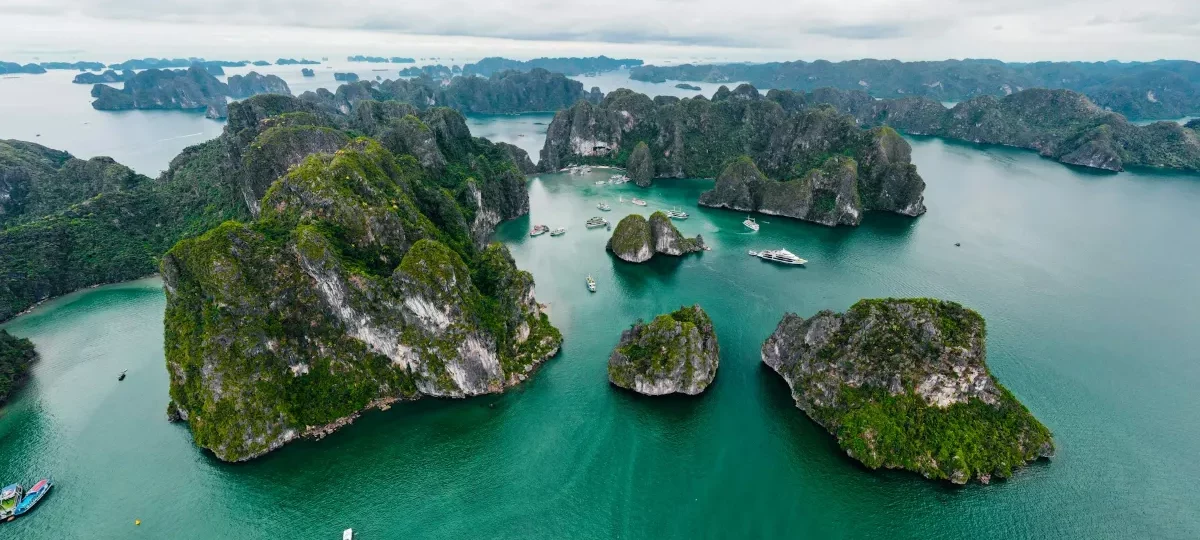 Aerial view of green limestone islands rising from turquoise water in Halong Bay, Quang Ninh, Vietnam
