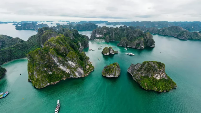 Aerial view of green limestone islands rising from turquoise water in Halong Bay, Quang Ninh, Vietnam