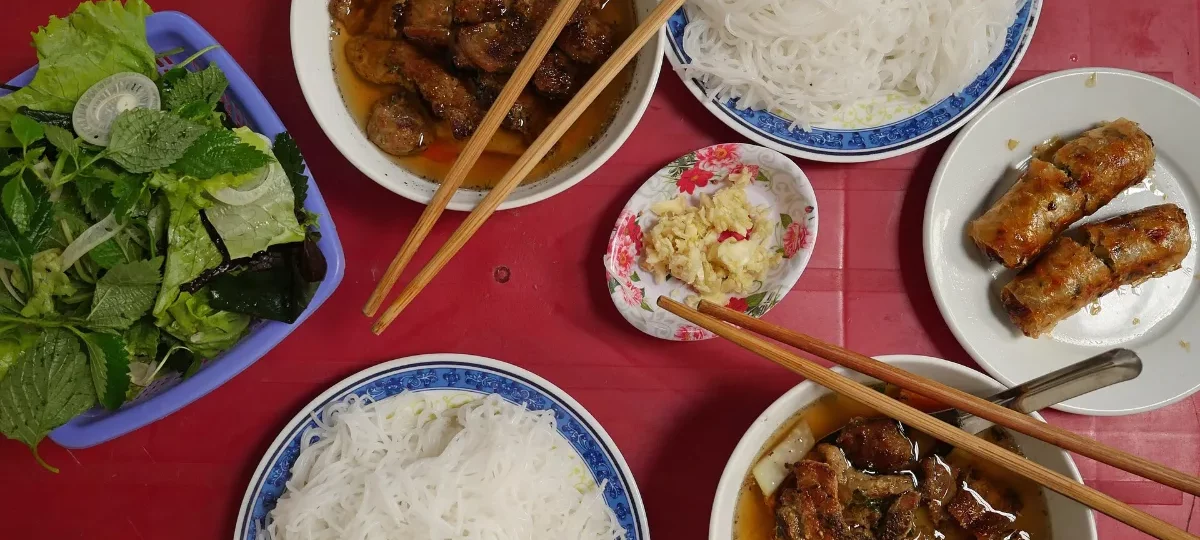 Hanoi bun cha: grilled pork in dipping broth with rice vermicelli, fresh herbs and nem ran spring rolls