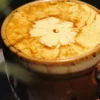 Cup of Hanoi egg coffee (cà phê trứng) with a thick golden egg foam topped with a flower pattern