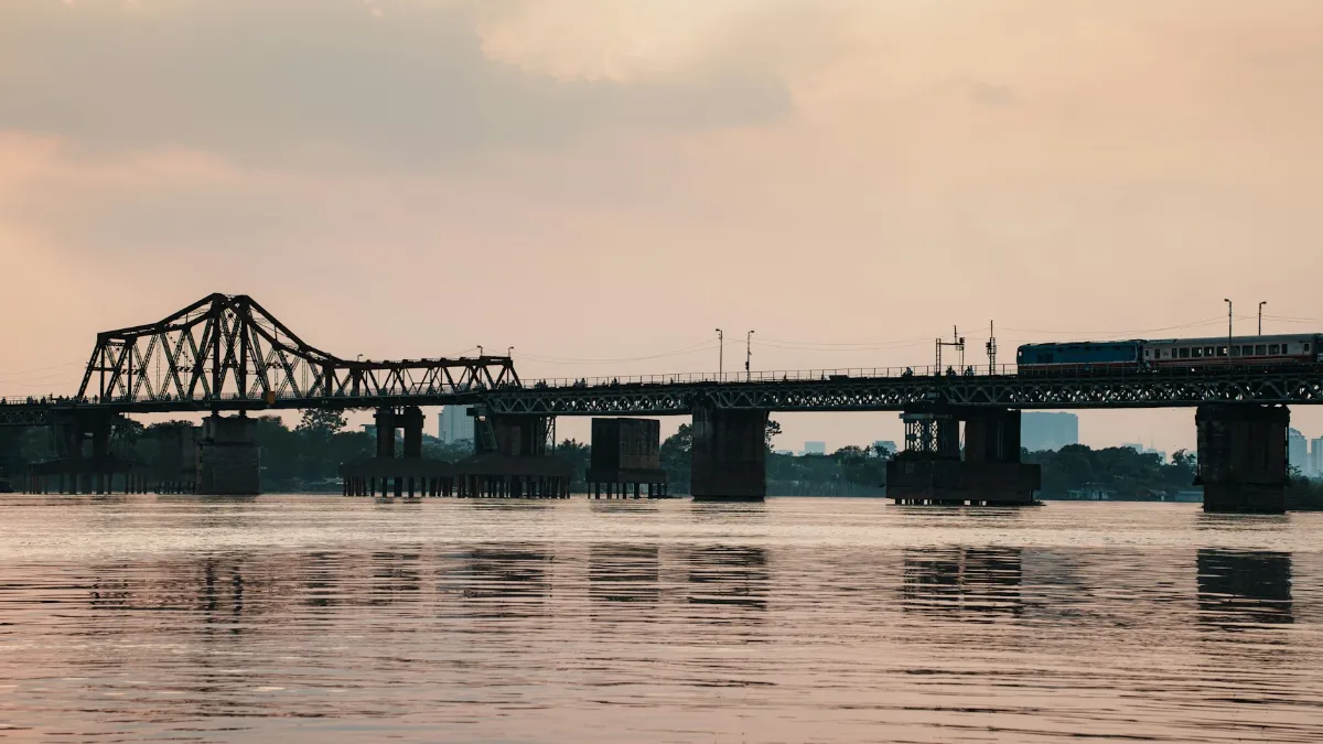 Hanoi Train Street – Train on Long Bien Bridge over the Red River A train crosses Long Bien Bridge over the Red River in Hanoi at dusk
