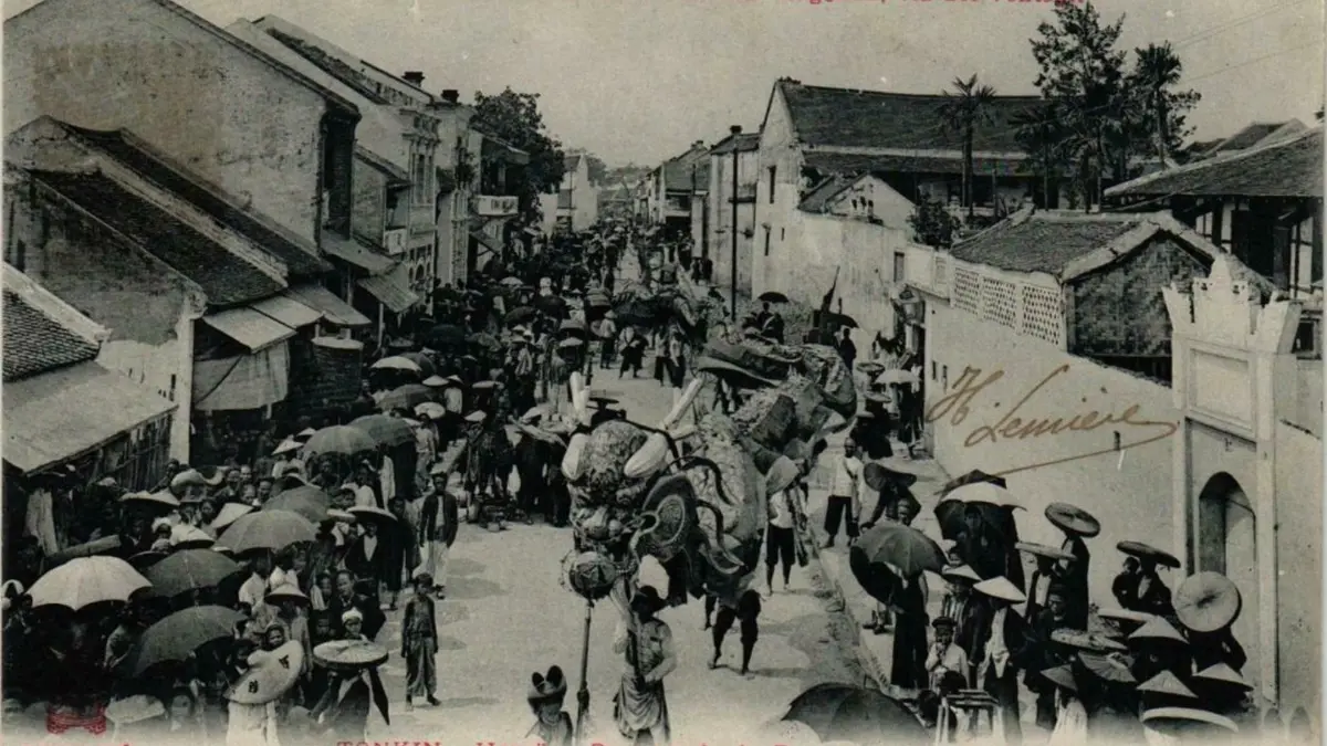Hanoi Old Quarter Around 1900 – Rue des Éventails Historic photo of a dragon procession on Rue des Eventails in the Hanoi Old Quarter around 1900