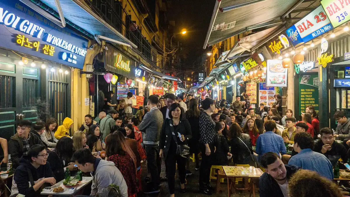 Street Food at Night in the Hanoi Old Quarter People eating street food at night on a busy street in the Hanoi Old Quarter
