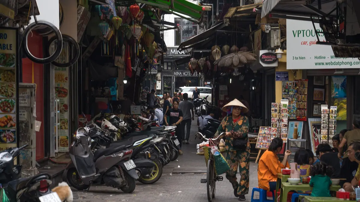Street Life in the Hanoi Old Quarter Busy narrow street with shops, motorbikes and a street vendor in the Hanoi Old Quarter