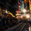 A train passes between crowded trackside cafés on Hanoi Train Street in the Old Quarter at dusk