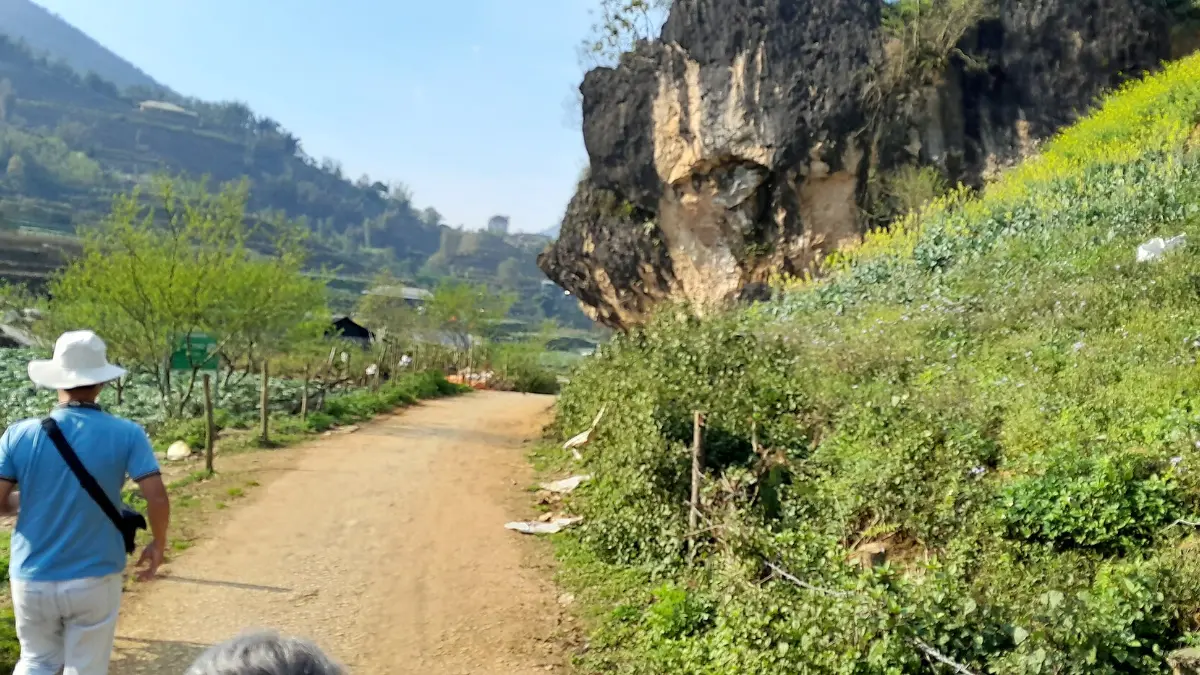 Hiking Trail near Ta Phin, Sapa Hiker on a trail beneath limestone cliffs in the hills near Ta Phin, Sapa