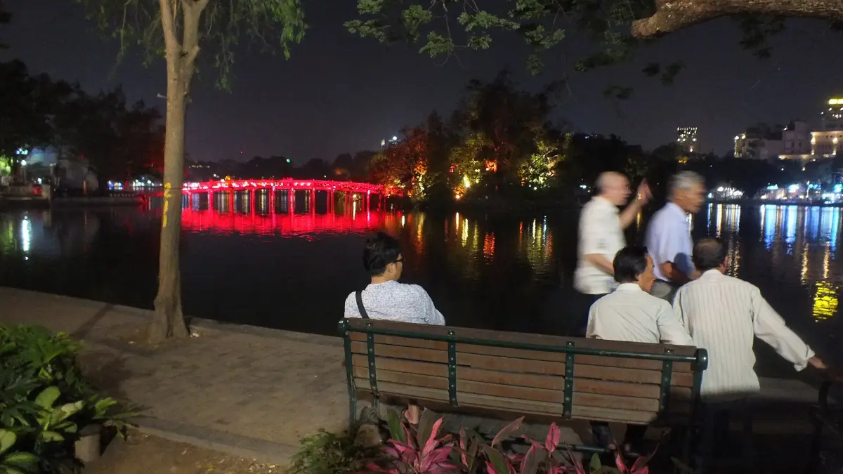 Hoan Kiem Lake in the Evening, Hanoi Walking Street Locals relaxing by Hoan Kiem Lake at night with the illuminated Huc Bridge