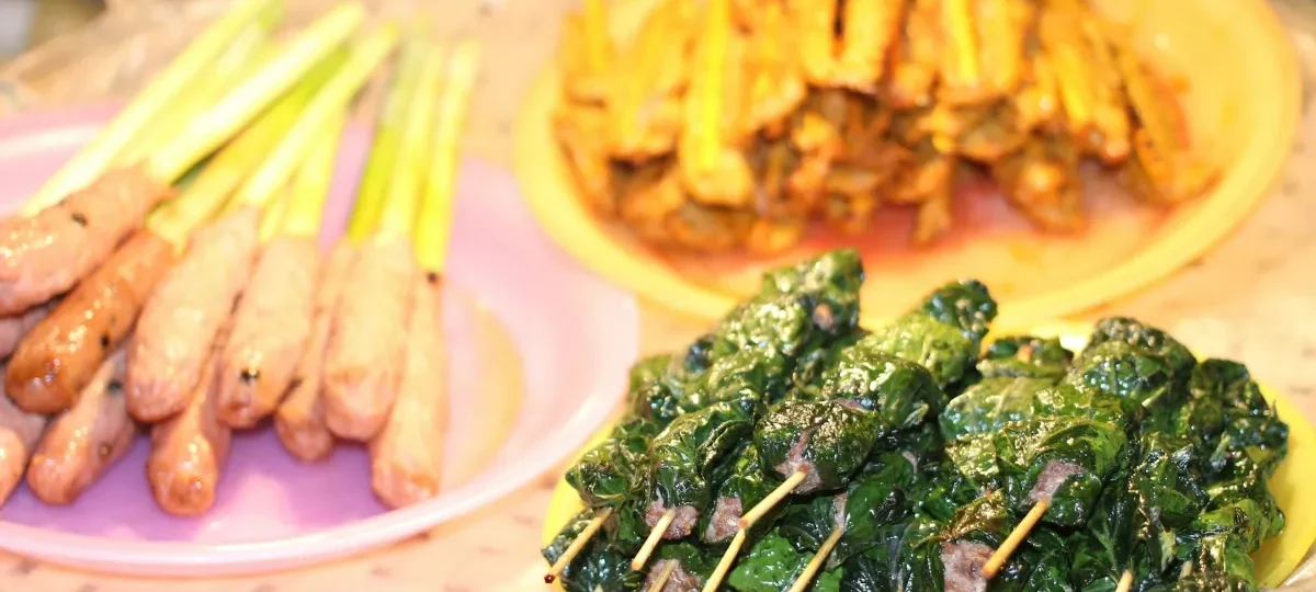 Grilled pork skewers and leaf-wrapped beef at Hoi An night market, a classic Hoi An street-food spread