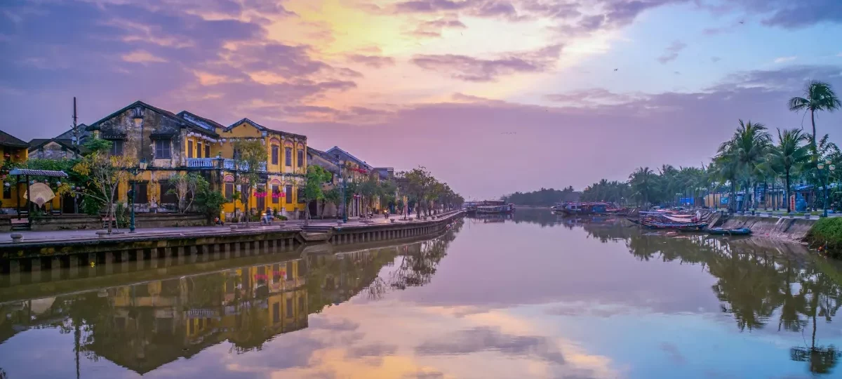 Sunset over the Thu Bon River and yellow riverside houses of Hoi An, a popular area to stay in Hoi An
