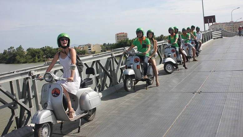Vespas crossing a bridge on a day ride in central Vietnam