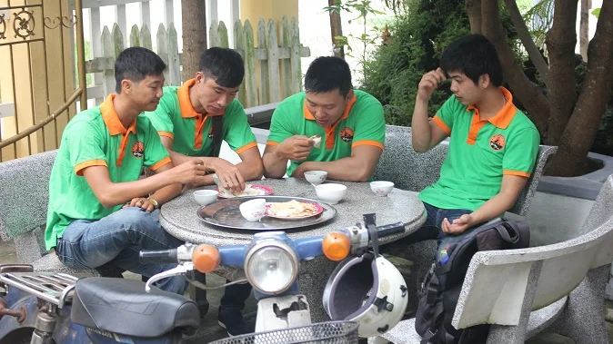 Vespa team sharing local food around a table in Hoi An