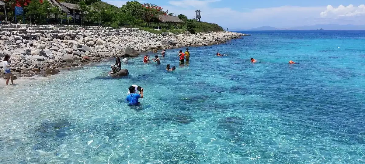 Clear turquoise water and rocky shore at Hon Mun Island, Nha Trang
