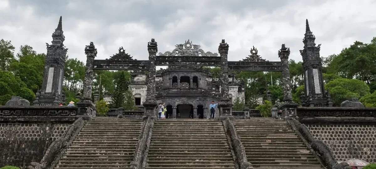 Grey stone terraces and buildings of Khai Dinh Tomb on a hillside near Hue