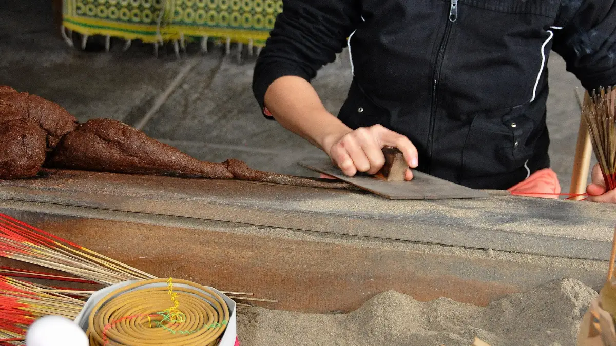 Woman demonstrating how incense sticks are made, Hue