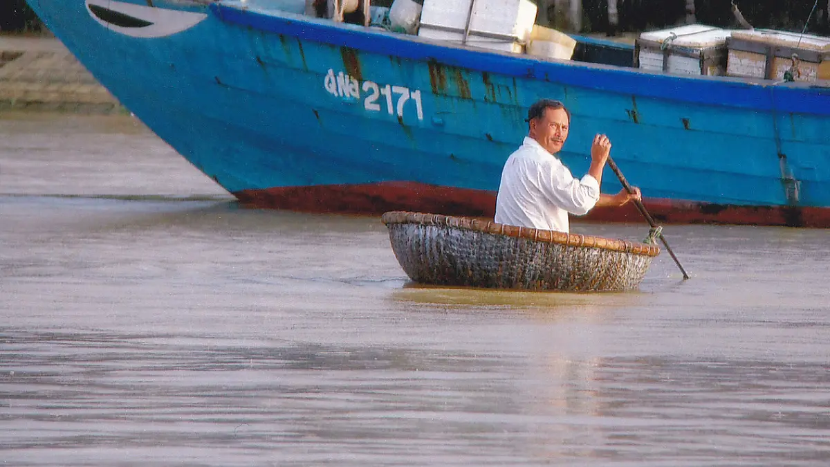 Rowing a Basket Boat Man rowing a round basket boat in central Vietnam
