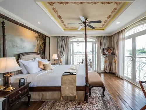 Suite bedroom with French doors and river view on the Mekong Princess