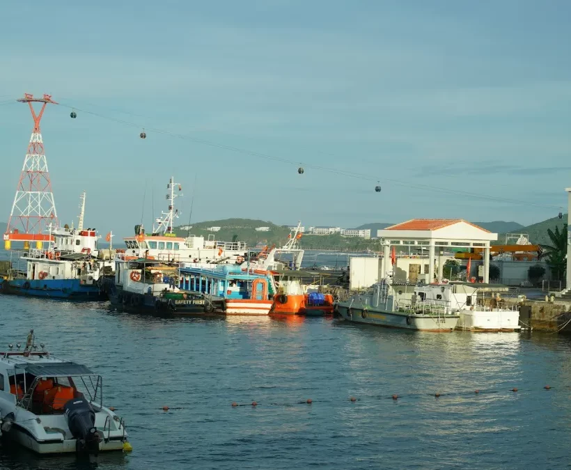 Island tour boats moored at a Nha Trang harbour with the sea cable car to Hon Tre Island overhead