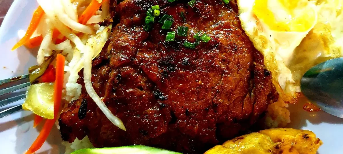 Cơm tấm in Saigon: broken rice with grilled pork chop, fried egg and pickles