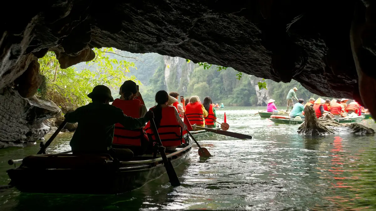 Boat Passing Through a Cave in Trang An Tourist boats entering a low water cave on the Trang An boat trip, Ninh Binh