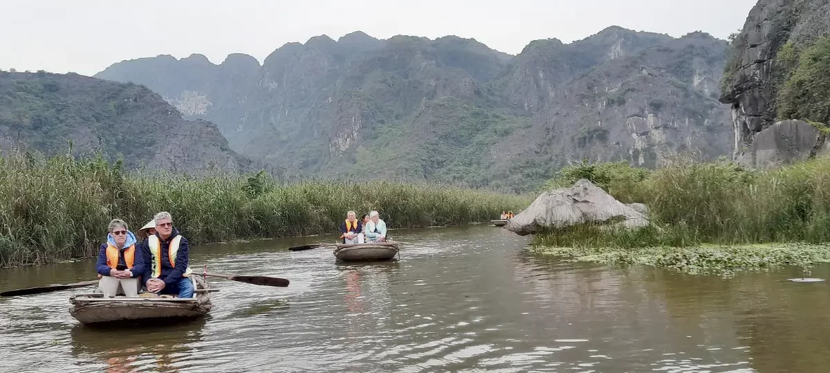 Bamboo boats on the calm Van Long lagoon surrounded by karst mountains, Ninh Binh