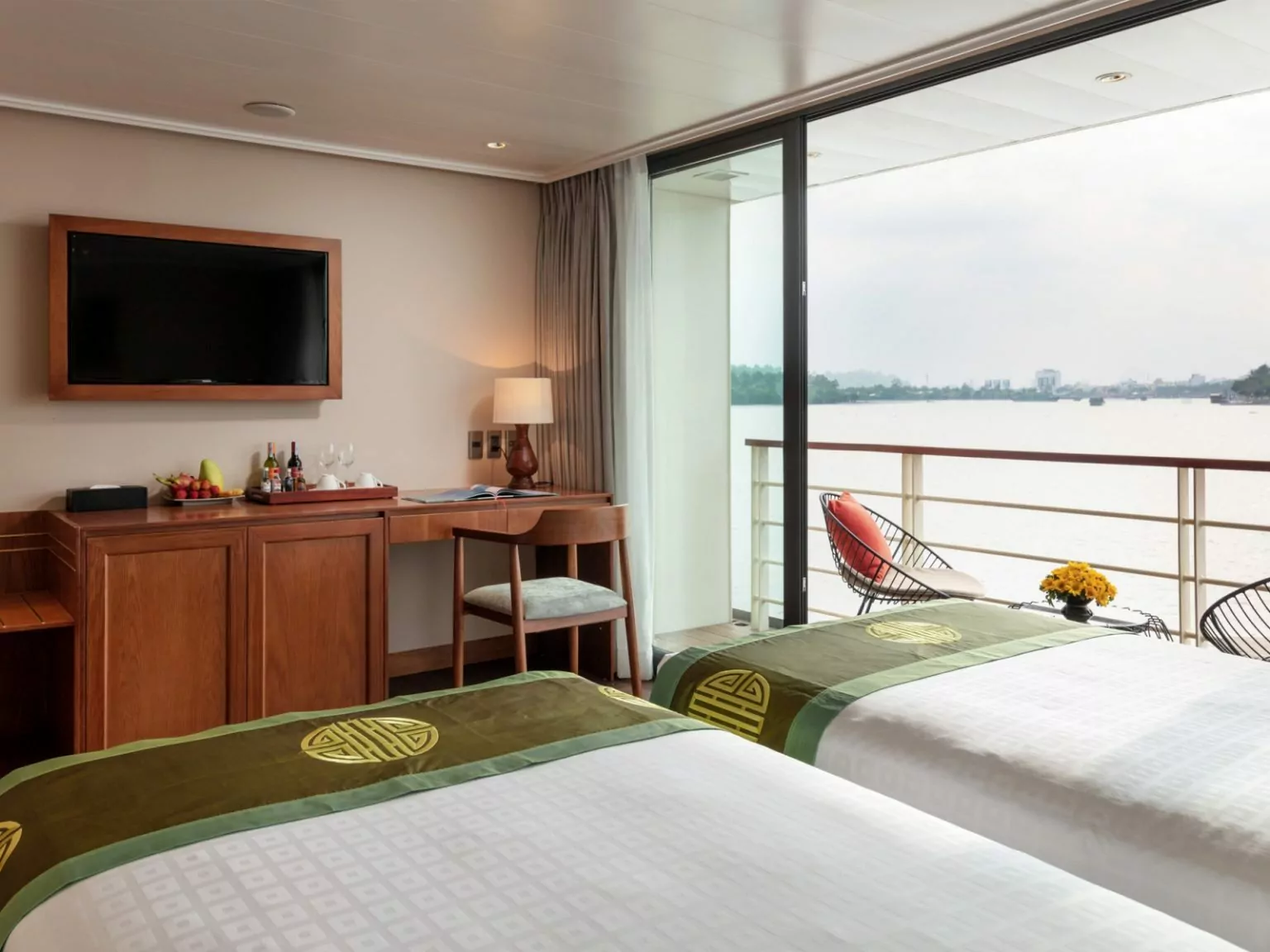 Writing desk, TV and private balcony door in a Victoria Mekong Deluxe cabin