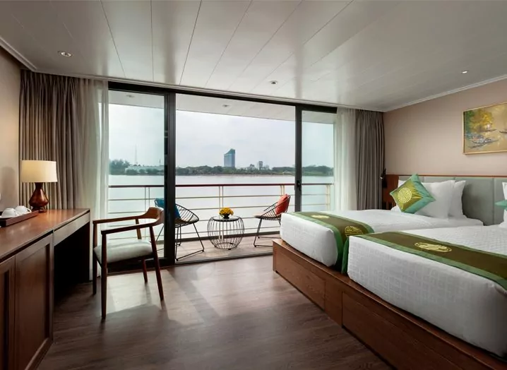 Deluxe cabin with double bed, writing desk and balcony view on the Victoria Mekong cruise
