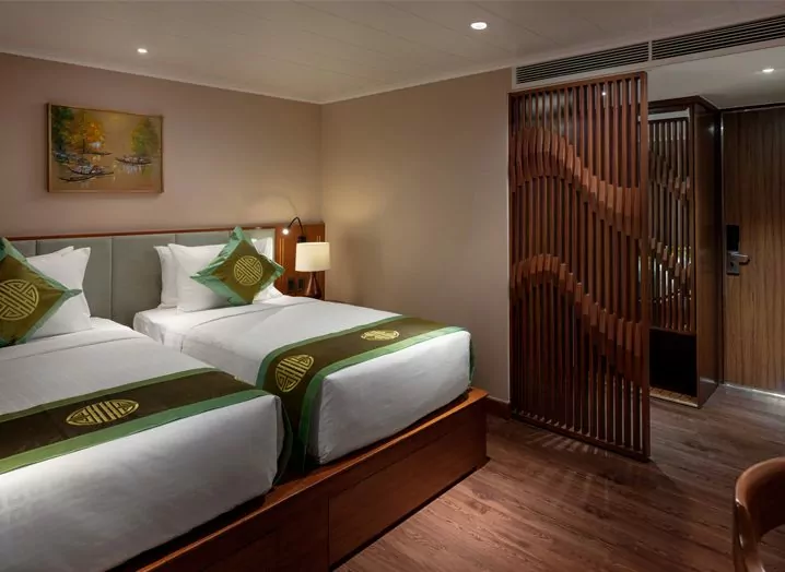 Deluxe cabin with twin beds and wooden lattice screen on the Victoria Mekong cruise