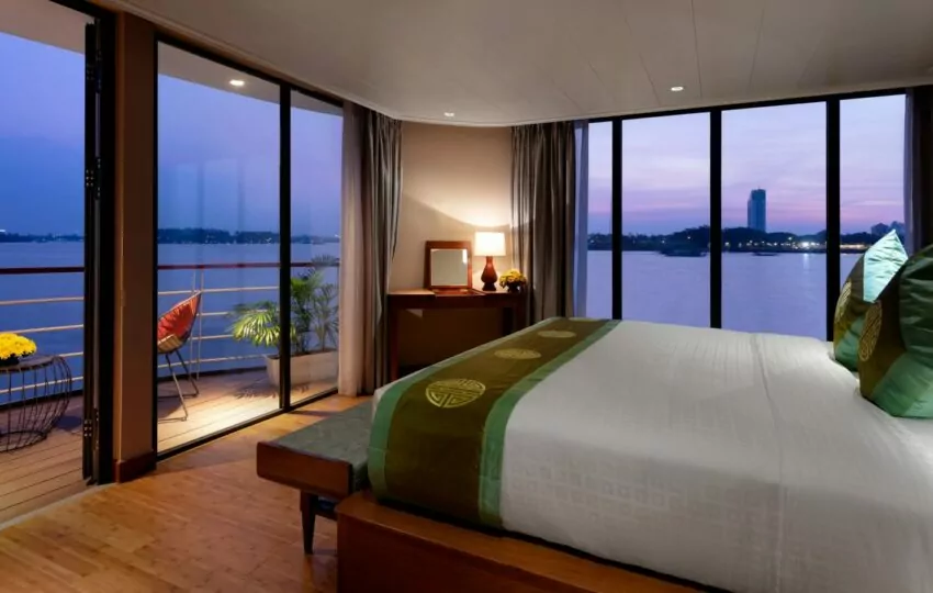 Victoria Mekong Suite bedroom with panoramic windows over the Mekong River