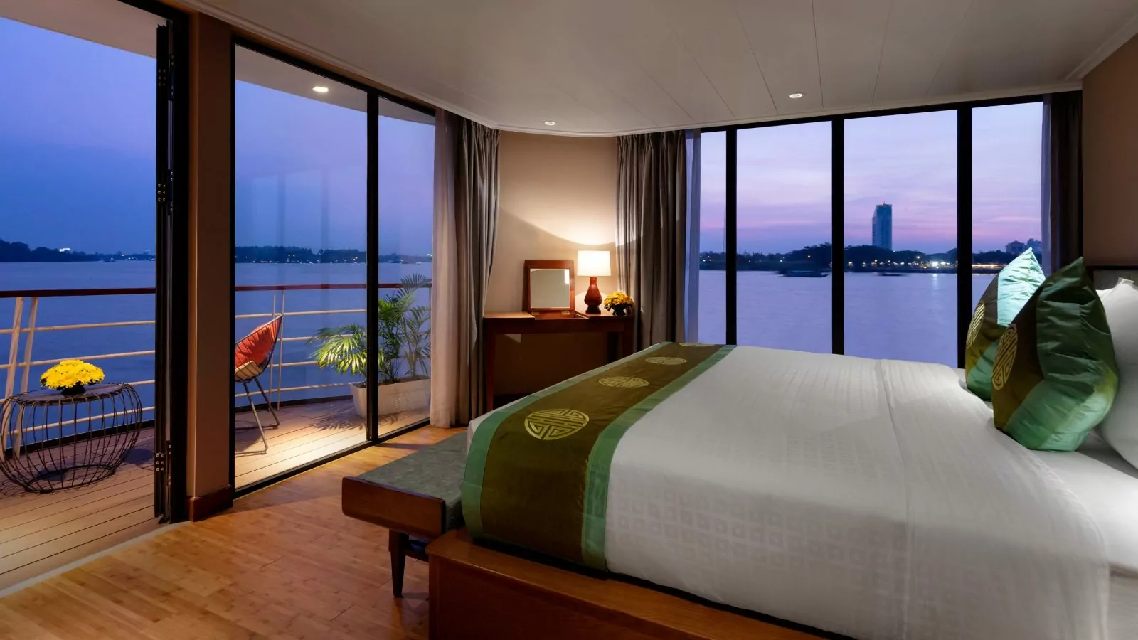 Victoria Mekong Suite bedroom with panoramic windows over the Mekong River