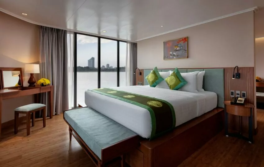 Victoria Mekong Suite double bed with dressing table and floor-to-ceiling river-view windows