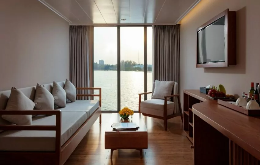 Separate living area with sofa, armchair and TV in a Victoria Mekong Suite