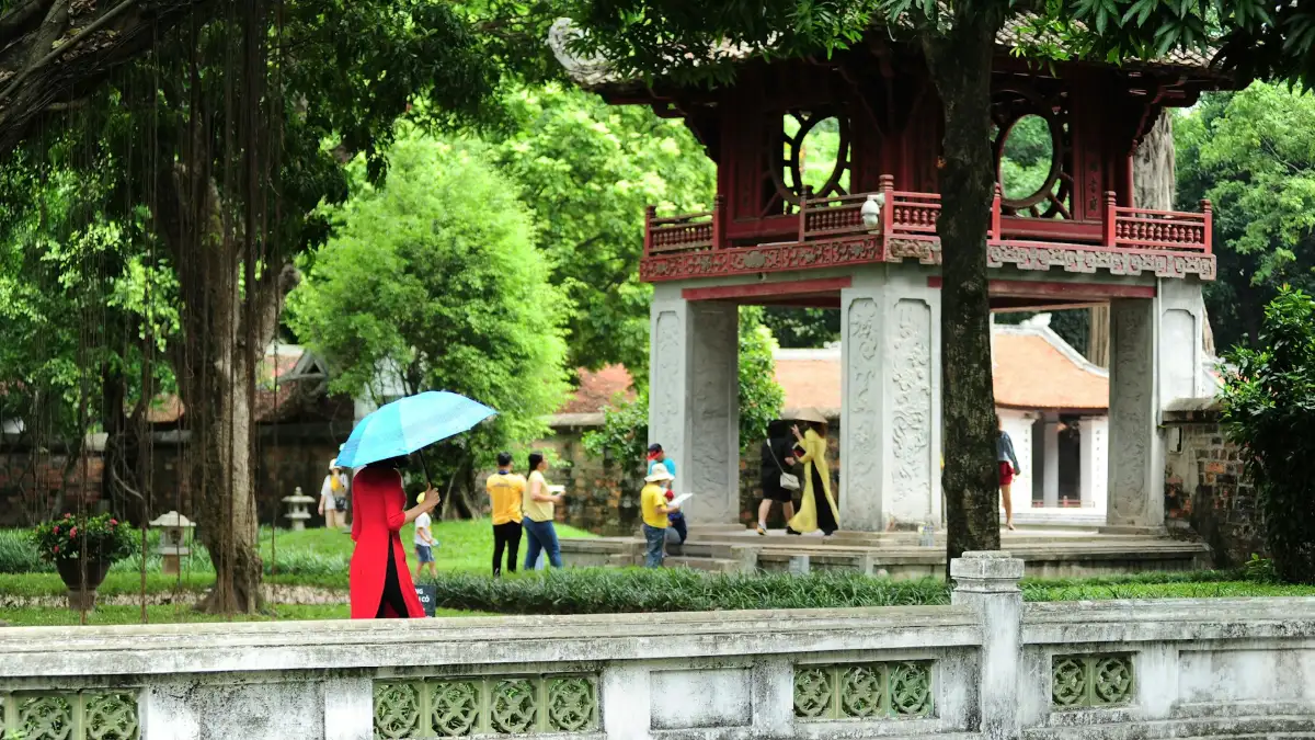 Visitors in the gardens of the Temple of Literature Visitors walking through the gardens of the Temple of Literature in Hanoi