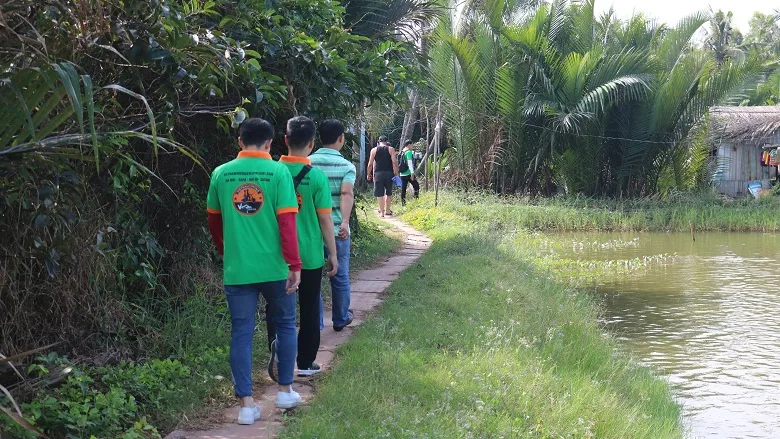 Walking by village ponds in the Mekong Delta